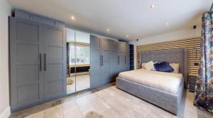 1 dormitorio con 1 cama grande y puertas de cristal en The Bungalow by The Garden Spa Stays, 4 bed, Sauna - Hot Tub - Ice Bath, en Radstock 26 fotos más