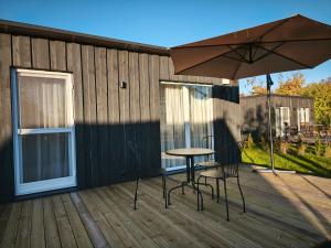 a table and chairs on a deck with an umbrella at Gervių takas 2 