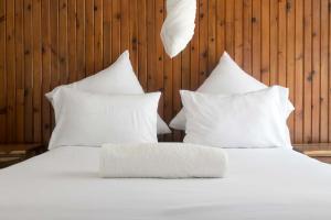 a white bed with white pillows in a room at Bwinji Mfumu Lodge in Chongwe