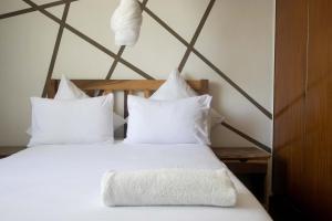 a bed with white sheets and pillows in a room at Bwinji Mfumu Lodge in Chongwe