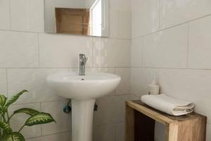 a white bathroom with a sink and a mirror at Bwinji Mfumu Lodge in Chongwe