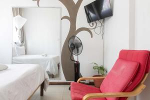 a bedroom with a red chair and a mirror at Bwinji Mfumu Lodge in Chongwe
