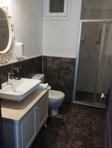 Un baño con inodoro, lavabo y ducha. en Noonbir Alaçatı otel, en Cesme