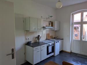 a kitchen with white cabinets and a stove top oven at Rathsacks Familienhof in Ziegendorf