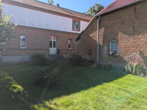 a brick house with a yard in front of it at Rathsacks Familienhof in Ziegendorf