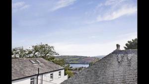 two roofs of houses with a lake in the background at Grace Cottage-a 4 bedroom period cottage in Teignmouth