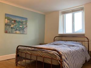 a bedroom with a bed and a window at Grace Cottage-a 4 bedroom period cottage in Teignmouth