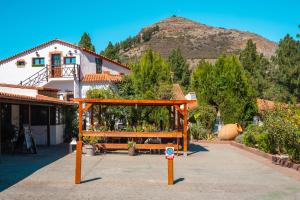 a pavilion in front of a house with a mountain at La Buhardilla del Refugio - For hikers, senderistas in Tejeda