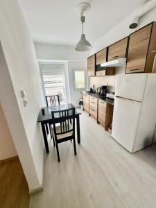 een keuken met een tafel en een witte koelkast bij 55sm apartment Voula 4pax in Athene
