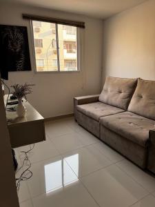 un salon avec un canapé et une table dans l'établissement Cozy 2-Bedroom Apartment 2 km from the Airport, à Várzea Grande 3 autres photos