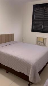 - un lit blanc dans une chambre avec fenêtre dans l'établissement Cozy 2-Bedroom Apartment 2 km from the Airport, à Várzea Grande