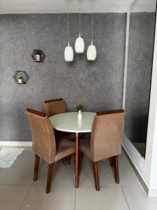 - une table à manger avec des chaises et des lampes suspendues dans l'établissement Cozy 2-Bedroom Apartment 2 km from the Airport, à Várzea Grande