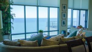 een woonkamer met een bank en uitzicht op de oceaan bij Penthouse Jr Unrivaled Luxury Insane Views in South Padre Island