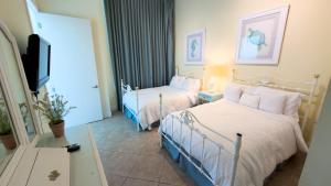 een hotelkamer met twee bedden en een flatscreen-tv bij Penthouse Jr Unrivaled Luxury Insane Views in South Padre Island +239 foto's