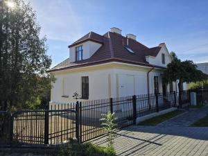 een wit huis met een zwart hek bij Apartamenty CAPPUCCINO in Przemyśl