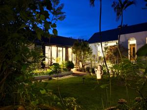 una casa con jardín por la noche en Fieldlight pool Villa, en Mae Rim