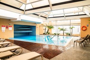 a pool in a building with chairs and a table at Casa Andina Premium Miraflores in Lima