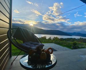een stoel op een veranda met uitzicht op een meer bij Azimuth in Buhalniţa +3 foto's