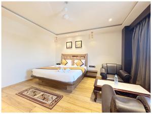 Un dormitorio con una cama y una mesa y sillas. en Near Jagannatha Temple Puri HGH-Grand Heritage #Rooftop Pool, en Puri 86 fotos más