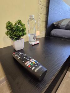 een afstandsbediening op een tafel met een fles water bij Private stay place in Sofia +4 foto's