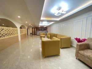 a lobby with couches and chairs in a building at The Imperia in Guwahati +1 photo