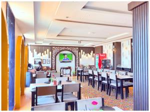 Un comedor con mesas y sillas en un restaurante. en Near Jagannatha Temple Puri HGH-Grand Heritage #Rooftop Pool, en Puri