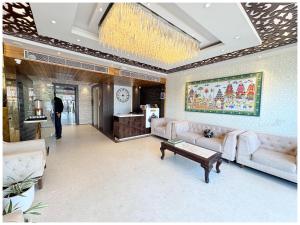 Una sala de estar con sofás y una lámpara de araña. en Near Jagannatha Temple Puri HGH-Grand Heritage #Rooftop Pool, en Puri