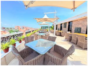 Un patio con una mesa y sillas en un balcón. en Near Jagannatha Temple Puri HGH-Grand Heritage #Rooftop Pool, en Puri