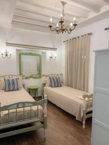 a bedroom with two beds and a mirror and a chandelier at La Maison de haut in Tunis