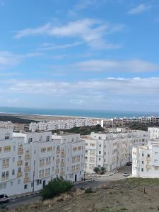 un grupo de edificios blancos con el océano en el fondo en Dar ilham, en Tánger