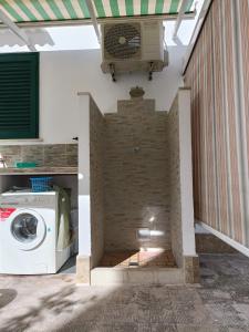 eine Waschmaschine und einen Trockner in einem Zimmer mit Ziegelwand in der Unterkunft Dimora Vincenzo in Gallipoli