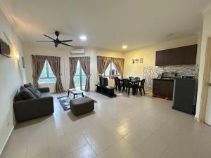 a living room with a ceiling fan and a kitchen at Tiara Homestay Desaru - Nature view in Bandar Penawar
