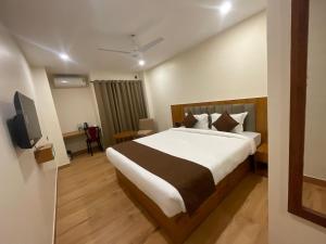 a hotel room with a bed and a television at The Imperia in Guwahati