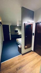 a room with a bedroom with a bed and a mirror at Hidden Negombo By Sana's in Negombo