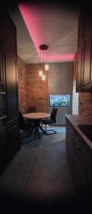 a dining room with a table and a pink lighting at Apartament centrum - loft Plac Piłsudskiego in Gliwice