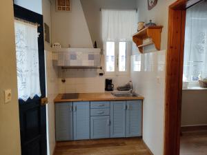 uma pequena cozinha com armários azuis e um lavatório em Sea Side Studio with Balcony and Sea View em Ayía Kiriakí