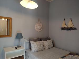 um quarto com uma cama, um espelho e um candeeiro em Sea Side Studio with Balcony and Sea View em Ayía Kiriakí