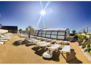 - une rangée de chaises longues blanches sur une plage dans l'établissement DOMA Mobil home 3 chambres Litteau, à Litteau