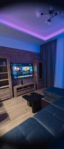 a living room with a tv and a couch at Apartament centrum - loft Plac Piłsudskiego in Gliwice +6 photos