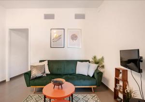 a living room with a green couch and a table at Norma House on the Rocks in Norma +16 photos