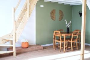 Un comedor con mesa y sillas y una escalera. en L'atypique des choux, en Les Choux