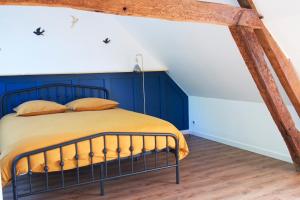 Un dormitorio con una cama con una pared azul. en L'atypique des choux, en Les Choux