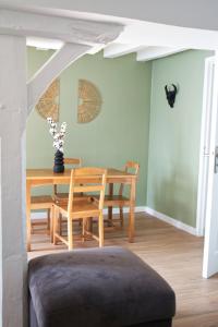 Un comedor con mesa y sillas de madera. en L'atypique des choux, en Les Choux