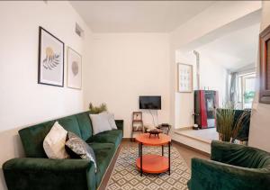 a living room with a green couch and a table at Norma House on the Rocks in Norma