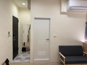 a white door in a room with a chair at Jian Guo Hotel in Pingtung City
