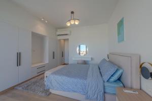 a white bedroom with a bed and a mirror at Lumina -1 BR Chalet in Kamaran, Gouna in Hurghada
