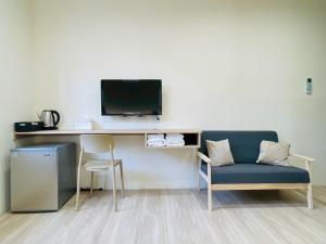 a room with a desk with a tv and a chair at Jian Guo Hotel in Pingtung City