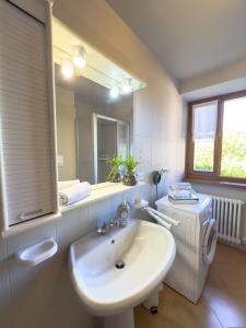 a white bathroom with a sink and a mirror at Al Veciarin in Lundo