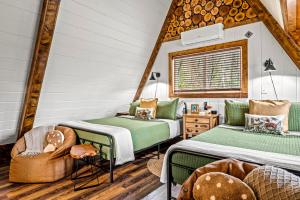 ein Zimmer mit zwei Betten und einem Stuhl in der Unterkunft High Bear Activity, Handicap Ramp, Hot Tub, Fire Table, Game Room, Family Cabin in Gatlinburg