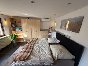 a bedroom with a bed with a blanket on it at M-Suites Petit - Near Frankfurt Airport in Hattersheim